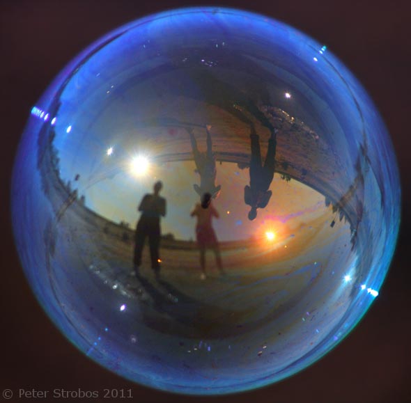 Figures reflected in a blue soap bubble.