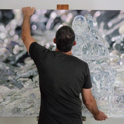 Artist Peter Strobos resting his painting on an easel.