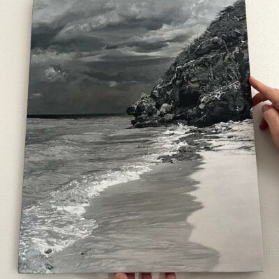 Artist holding up the newly completed monochrome seascape painting , Sapphire by Peter Strobos.