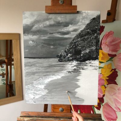 Studio scene of the artist adding brush detail to a monochrome seascape painting, Sapphire by Peter Strobos.