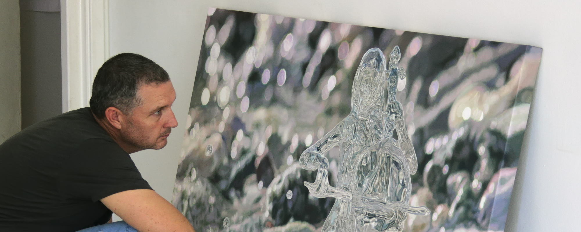 Artist Peter Strobos inspecting a recently completed oil painting in his studio on Curaçao.